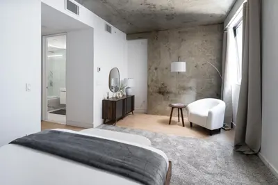 a bedroom with a bed and a mirror and a chair at Chic and Spacious 2BD Apt with washer and dryer in unit in New York