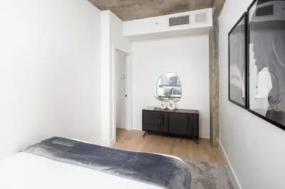 a white bedroom with a bed and a mirror at Chic and Spacious 2BD Apt with washer and dryer in unit in New York