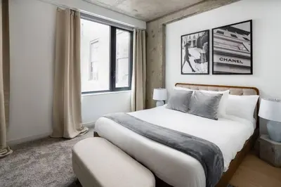 a bedroom with a large bed and a window at Stunning 2BD Penthouse in Chelsea w Washer and Dryer in New York
