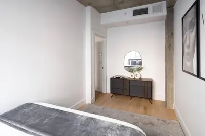 a bedroom with a bed and a mirror on the wall at Stunning 2BD Penthouse in Chelsea w Washer and Dryer in New York