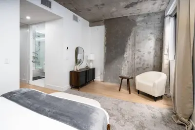 a bedroom with a bed and a mirror and a chair at Stunning 2BD Penthouse in Chelsea w Washer and Dryer in New York