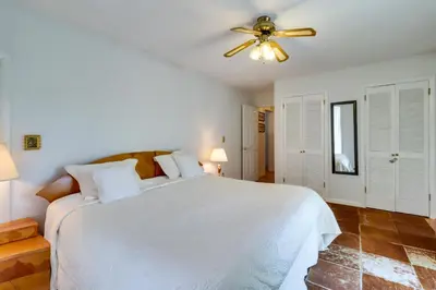 a bedroom with a white bed and a ceiling fan at Fire Pit, Kayaks and Hammocks Long Pond Home! in Long Pond