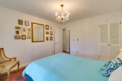a bedroom with a blue bed and a chandelier at Fire Pit, Kayaks and Hammocks Long Pond Home! in Long Pond