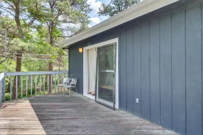 a porch of a blue house with a chair on it at Fire Pit, Kayaks and Hammocks Long Pond Home! in Long Pond