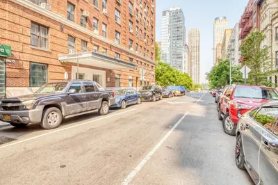 a row of parked cars parked on a city street at Upper W Side 1BR w Gym by Lincoln Sq NYC-331 in New York