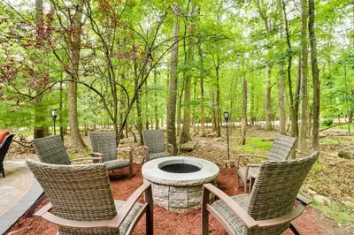 a group of chairs and a fire pit in the woods at Game Room and Hot Tub Ski Getaway in Poconos! in East Stroudsburg