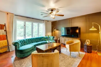 a living room with a blue couch and a tv at Game Room and Hot Tub Ski Getaway in Poconos! in East Stroudsburg