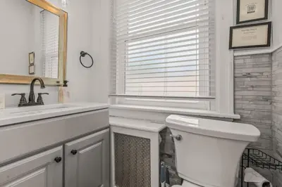 a bathroom with a toilet and a sink and a window at King Bed Gym Parking AC Train in Narberth
