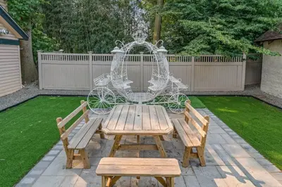 a wooden table with two benches and a chandelier at King Bed Gym Parking AC Train in Narberth