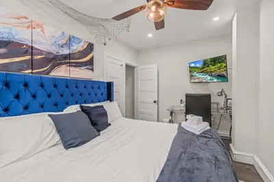 a bedroom with a large bed with a blue headboard at King Bed Gym Parking AC Train in Narberth