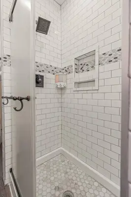 a bathroom with a shower with white tiled walls at Spacious Home King Beds Gym Deck Games Parking AC in Narberth