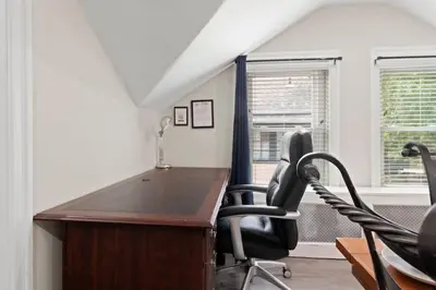 an attic office with a desk and two chairs at Spacious Home King Beds Gym Deck Games Parking AC in Narberth