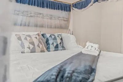 a white bed with pillows and a blanket on it at Spacious Home King Beds Gym Deck Games Parking AC in Narberth