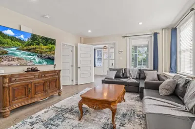 a living room with a couch and a table at Spacious Home King Beds Gym Deck Games Parking AC in Narberth