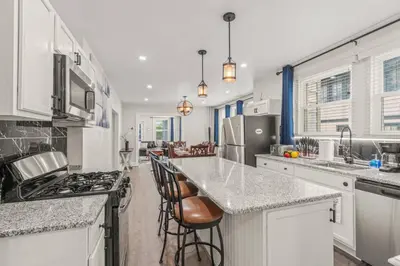 a kitchen with white cabinets and a counter top at Spacious Home King Beds Gym Deck Games Parking AC in Narberth