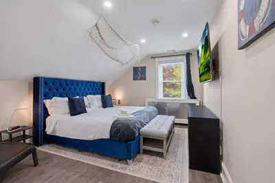 a bedroom with a blue bed and a window at 5 Star Penthouse King Deck AC Train in Narberth