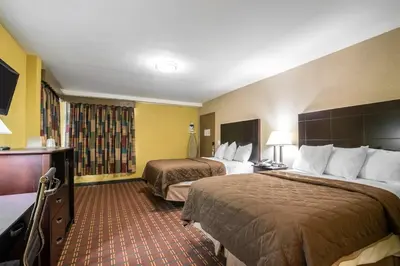 a hotel room with two beds and a television at Rodeway Inn Towanda in Towanda