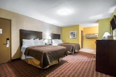 a hotel room with two beds and yellow walls at Rodeway Inn Towanda in Towanda