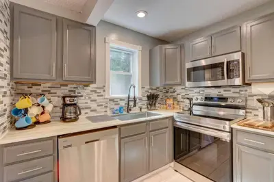 a kitchen with gray cabinets and a sink and a microwave at Cozy Chalet Game Rm and Fireplace in East Stroudsburg
