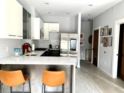 a kitchen with a counter and two orange chairs at Collect3 2BR 1BA Close to Train and NYC in Newark