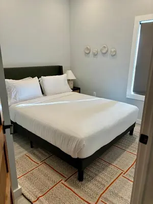 a bedroom with a large bed with white sheets at Collect3 2BR 1BA Close to Train and NYC in Newark