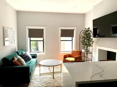a living room with a green couch and a table at Collect3 2BR 1BA Close to Train and NYC in Newark