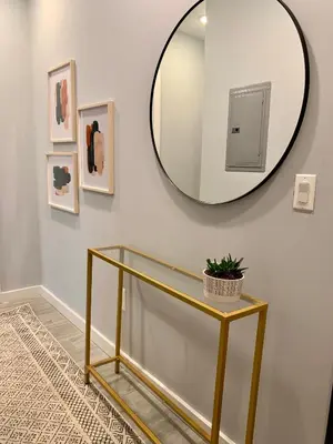 a mirror on a wall next to a table with a plant at Collect3 2BR 1BA Close to Train and NYC in Newark