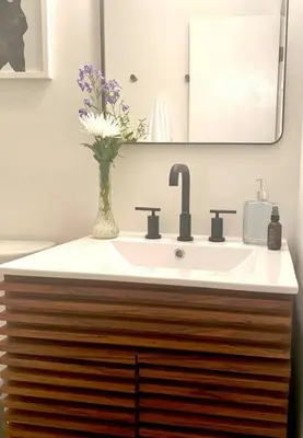 a bathroom with a sink and a vase of flowers at Chalet Retreat w/ Hot Tub, Short Walk to Lake & Pool in Jim Thorpe