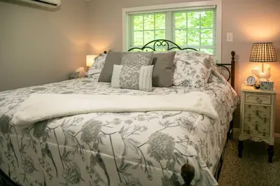 a bedroom with a bed with a floral bedspread and a window at Charming Manheim Cottage with On-Site Animal Viewing in Manheim