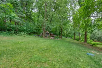 a yard with a house and a frisbee in the grass at Charming Manheim Cottage with On-Site Animal Viewing in Manheim