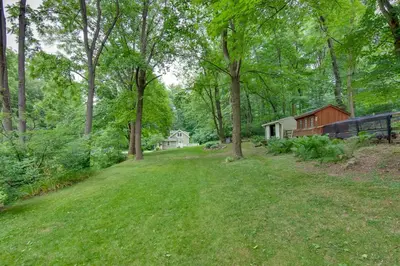 a yard with trees and a house in the background at Charming Manheim Cottage with On-Site Animal Viewing in Manheim
