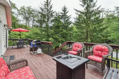 a patio with two chairs and a table on a deck at Tobyhanna Home with Fire Pits - 9 Mi to Kalahari! in Tobyhanna
