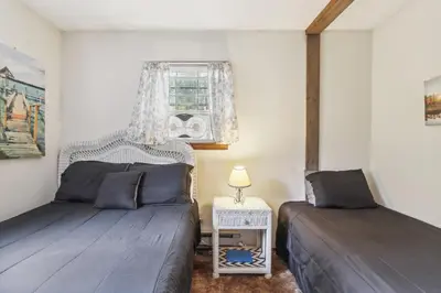 a bedroom with two beds and a table and a window at Tobyhanna Home with Fire Pits - 9 Mi to Kalahari! in Tobyhanna