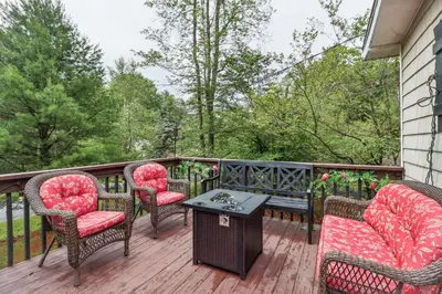 a porch with chairs and a table on a deck at Tobyhanna Home with Fire Pits - 9 Mi to Kalahari! in Tobyhanna