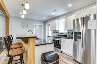 a kitchen with white cabinets and a stainless steel refrigerator at Large Historic Home in Pennsylvania Dutch Country! in Coatesville
