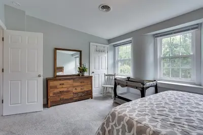 a bedroom with a bed and a dresser and a mirror at Large Historic Home in Pennsylvania Dutch Country! in Coatesville