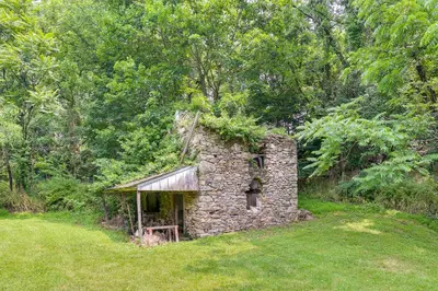 an old stone building in the middle of a field at Large Historic Home in Pennsylvania Dutch Country! in Coatesville