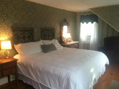 a bedroom with a large white bed and a window at The Frogtown Inn in Canadensis