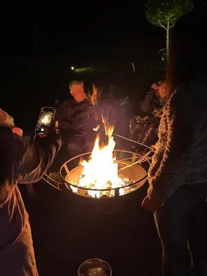 a group of people around a fire pit at night at The Frogtown Inn in Canadensis
