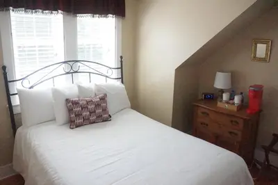 a bedroom with a bed with a pillow and a window at The Frogtown Inn in Canadensis
