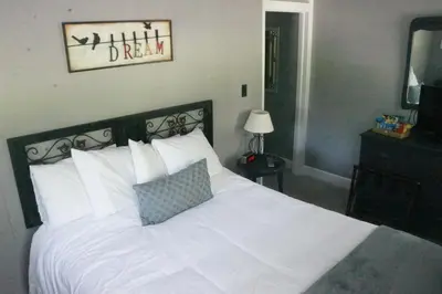 a bedroom with a white bed and a mirror at The Frogtown Inn in Canadensis