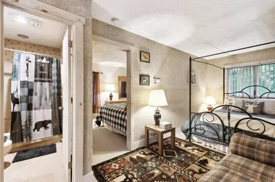 a hotel room with a bed and a living room at Lake Harmony Home with Screened Porch and Hot Tub! in Lake Harmony