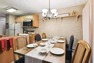 a dining room with a table with plates and wine glasses at Lake Harmony Home with Screened Porch and Hot Tub! in Lake Harmony