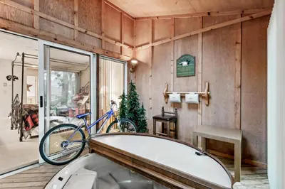 a bathroom with a tub and a bike on the wall at Lake Harmony Home with Screened Porch and Hot Tub! in Lake Harmony