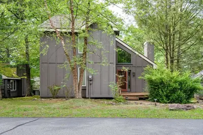 a home with a gray house with trees at Lake Harmony Home with Screened Porch and Hot Tub! in Lake Harmony