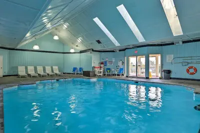 a large swimming pool with blue water in a building at Bushkill Home with Access to Pools and Tennis Courts! in Bushkill