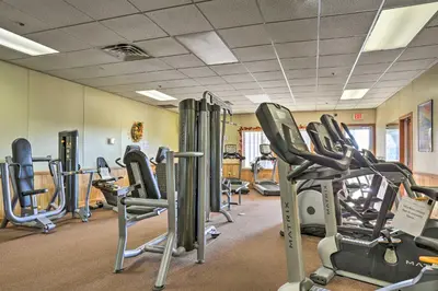 a gym with rows of treadmills and cardio machines at Bushkill Home with Access to Pools and Tennis Courts! in Bushkill