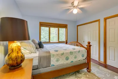 a bedroom with a bed and a table with a lamp at Bushkill Home with Access to Pools and Tennis Courts! in Bushkill