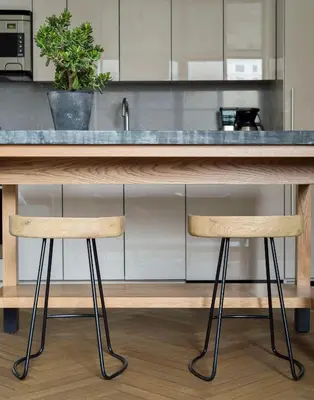 a kitchen with a counter with two wooden stools at ROOST Midtown in Philadelphia