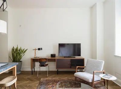 a living room with a tv and a table and chairs at ROOST Midtown in Philadelphia
